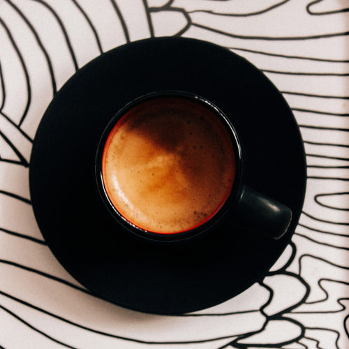 perfectly roasted espresso served in a black cup and saucer