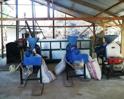 Toraja Coffee Growers Cooperative coffee farm infrastructure includes facilities such as this with coffee bagging equipment loading bags of beans.